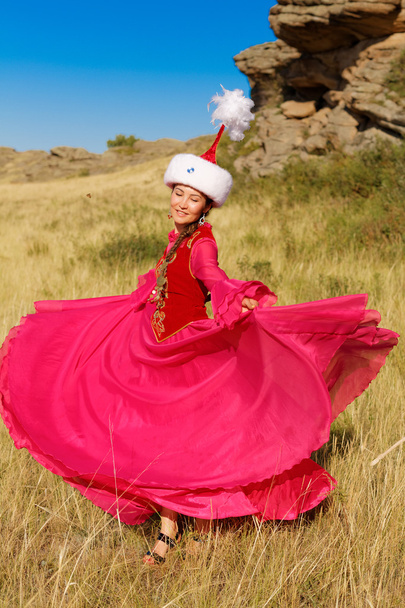 Hermosa mujer kazakh en traje nacional en la estepa bailando con dombyra
 - Foto, imagen