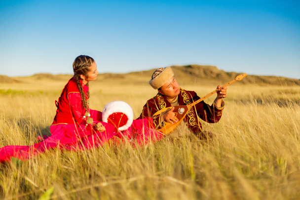 Kazah férfi és nő a népviseletet, a sztyepp, játszik a dombyra és a tánc - Fotó, kép