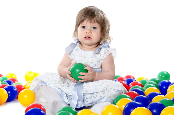 The little girl plays multi-coloured balls - Foto, afbeelding