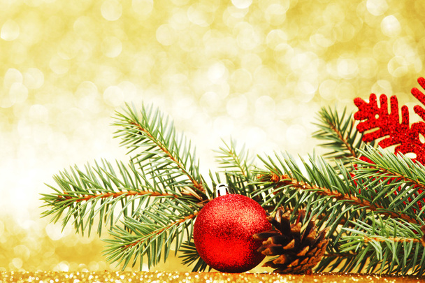 Tarjeta de Navidad con rama de abeto y decoración sobre fondo dorado brillo - Foto, Imagen