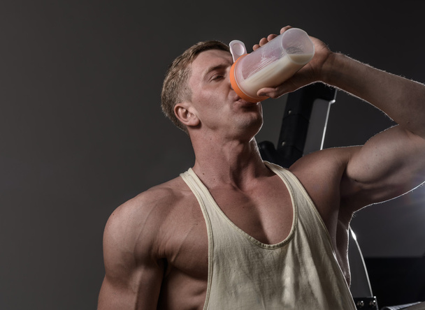 Athlete man drinking protein in gym - Photo, image