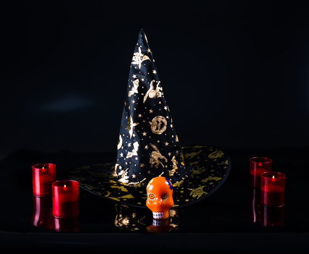 black fabric witch hat, candles isolated on black background - Valokuva, kuva
