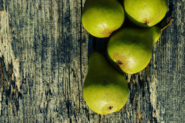 Fresh green pears against an old textural wooden surface. - Photo, Image