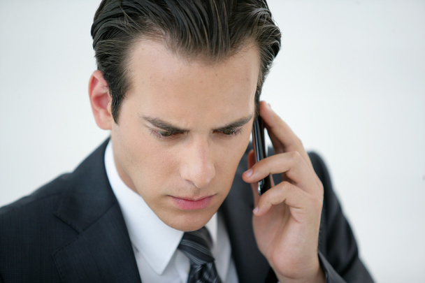 A concerned businessman talking on his mobile phone - Foto, afbeelding