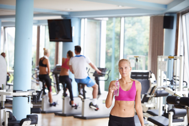 woman in fitness gym drinking water - 写真・画像