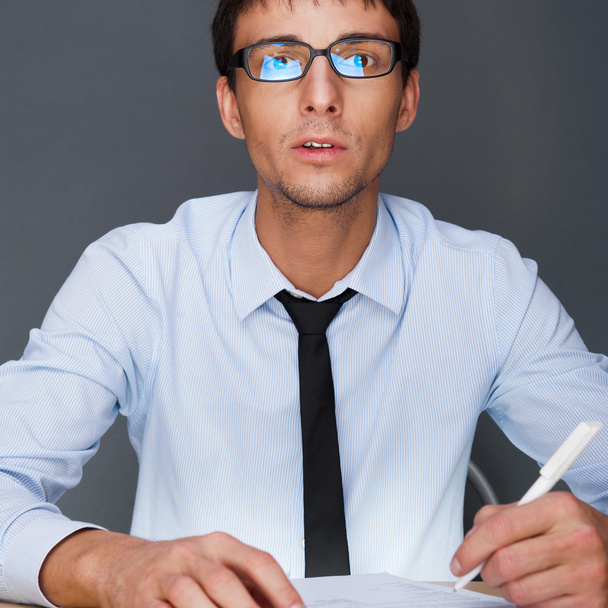 Portrait of an adult business man sitting in the office and sign - Фото, изображение