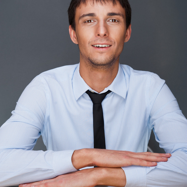 Portrait of young business man on a desk. He is sitting at his n - Foto, immagini