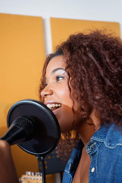 Young Woman Singing In Recording Studio - Foto, afbeelding