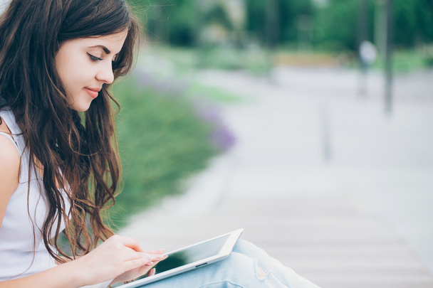 Girl holding tablet computer outdoors - Foto, imagen