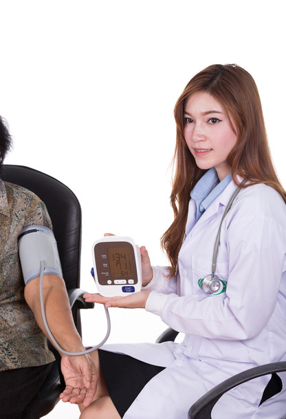 Female doctor measuring blood pressure of senior woman - Photo, Image