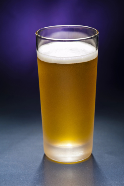 Bier pohár előtt egy színes háttérrel - Fotó, kép