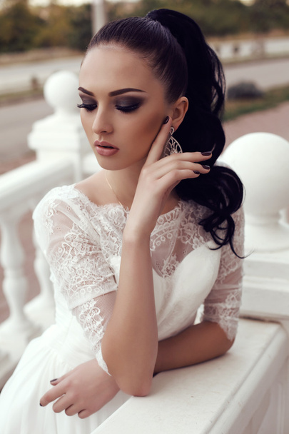 young woman with long dark hair in luxurious lace wedding dress - Foto, imagen