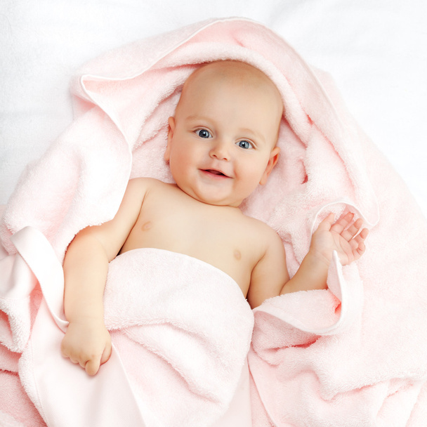 Valkoihoinen vauva poika peitetty vaaleanpunainen pyyhe iloisesti hymyilee noin
 - Valokuva, kuva