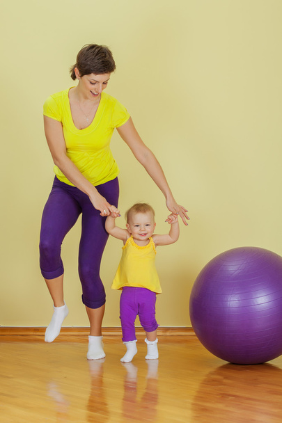 Mother do phisical exercises with her daughter at home - Photo, Image