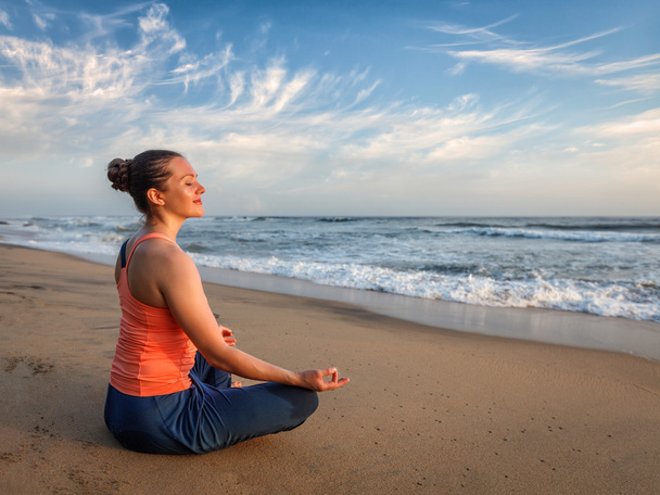 Jovem esportivo apto mulher fazendo ioga oudoors na praia
 - Foto, Imagem