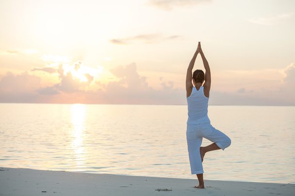 Caucasian woman practicing yoga at seashore - Photo, Image