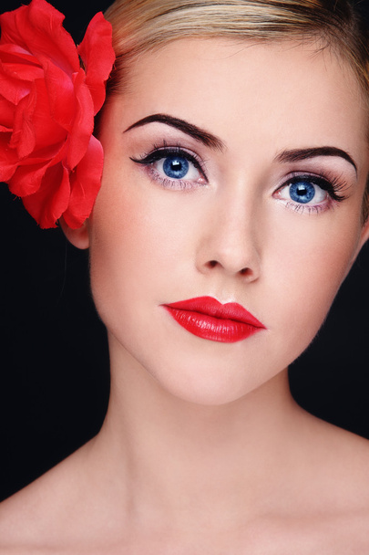 Young beautiful blond woman with red lipstick and red flower in her hair - Foto, Bild