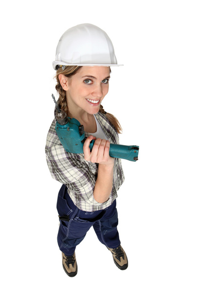 Una trabajadora de la construcción sosteniendo un taladro
. - Foto, Imagen