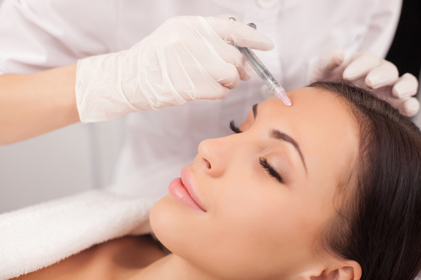 Professional cosmetologist is making procedure at clinic - Foto, imagen