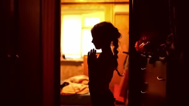 teen girl praying silhouette in a corridor brown evening religion - Footage, Video