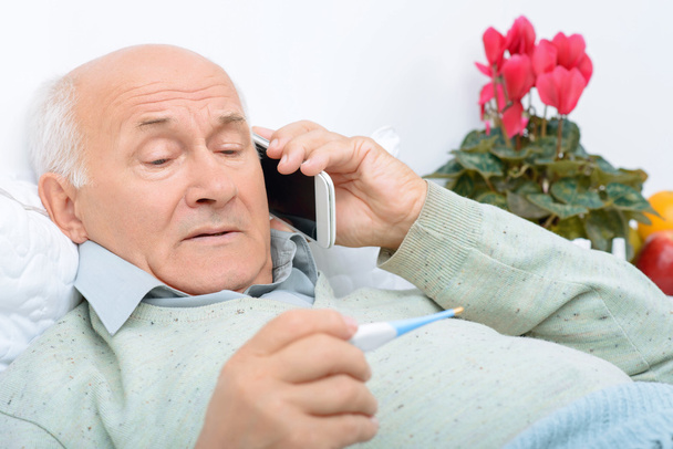 Despondent weary aged man calls up his relatives. - Фото, изображение