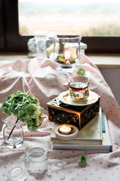 Φλιτζάνι τσάι σε ένα ρομαντικό δωμάτιο ρυθμίσεις με κεριά και λουλούδια - Φωτογραφία, εικόνα