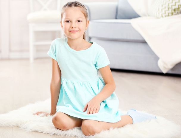Pequena menina bonito sentado no tapete
 - Foto, Imagem