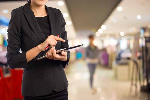 Vrouw met behulp van Tablet PC in shopping mall. - Foto, afbeelding