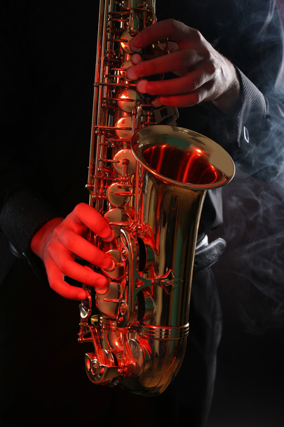 Музикант в чорній сорочці з саксофоном
  - Фото, зображення