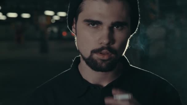 όμορφος νεαρός γενειοφόρος άνδρας κάπνισμα τσιγάρων - Πλάνα, βίντεο