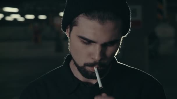 若いハンサムなひげを生やした男はタバコを吸って - 映像、動画