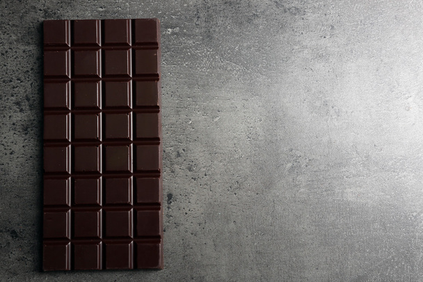 Chocolate bar on dark grey background - Fotoğraf, Görsel