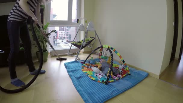 femme nettoyage sol avec nettoyant et bébé couché sur tapis de jeu. 4K
 - Séquence, vidéo