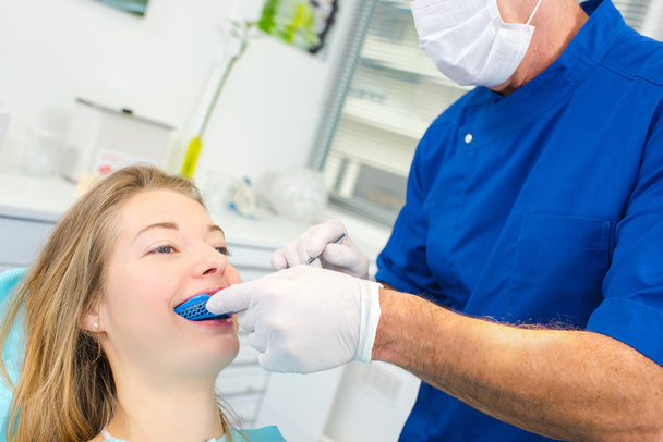 Woman having a routine dental check-up - Фото, изображение