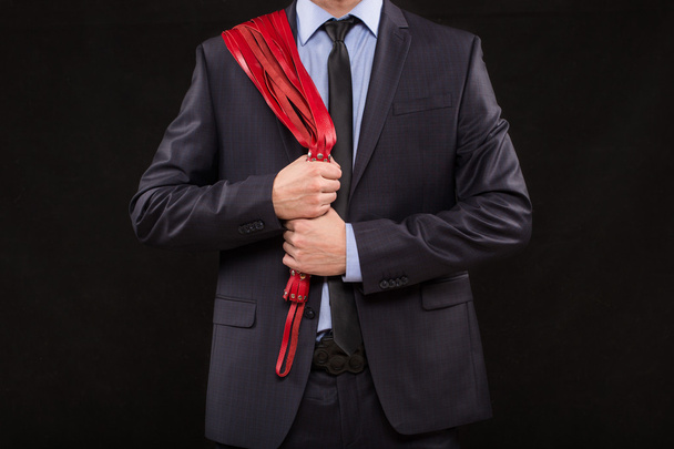 человек в деловом костюме с прикованными руками. наручники для секс-игр
 - Фото, изображение