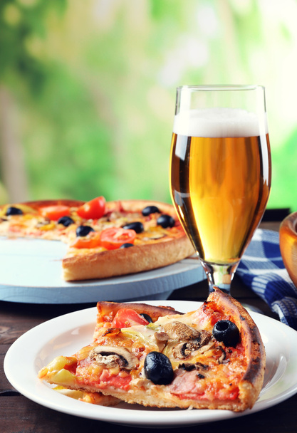 Pizza tarjoillaan oluen kanssa
 - Valokuva, kuva