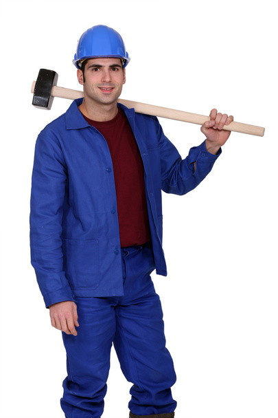 Construction worker holding a large mallet hammer - Фото, изображение
