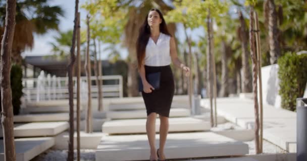 Mujer joven y segura caminando por un parque
 - Metraje, vídeo