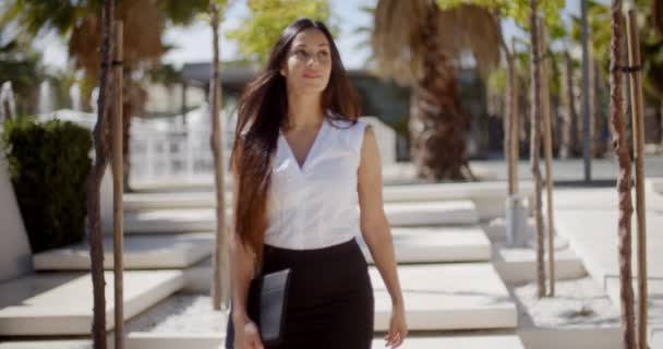 Young businesswoman walking through a park - Πλάνα, βίντεο
