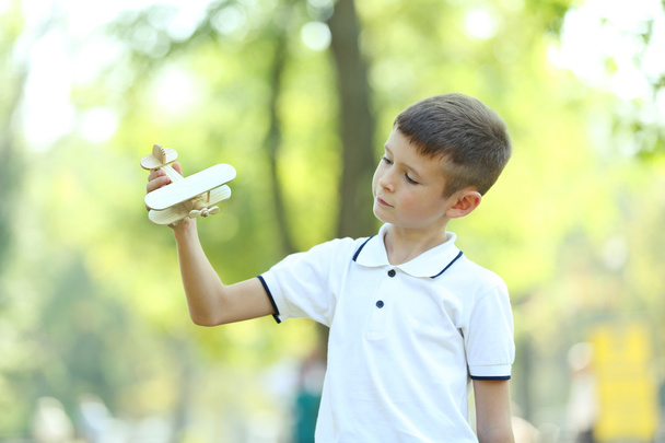 Jongetje speelt met houten vliegtuig  - Foto, afbeelding