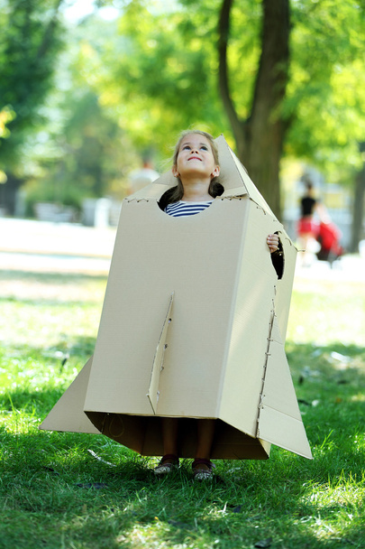 Little girl in carton rocket plays - Valokuva, kuva