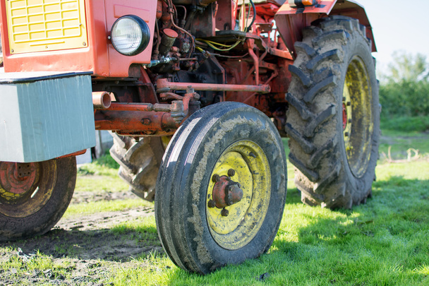 Ciągnik w pole. Zbliżenie stary traktor czerwony. - Zdjęcie, obraz