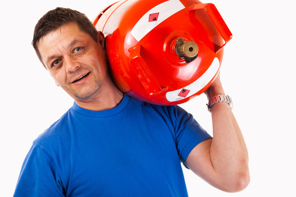 Un hombre con un cilindro de gas en el hombro
 - Foto, imagen
