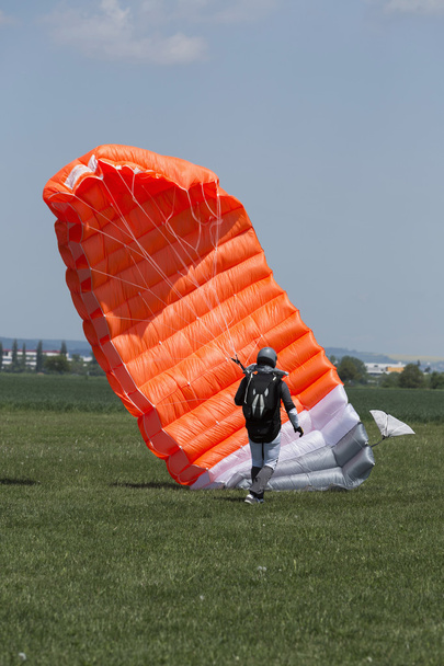 Parachutiste courant après avoir atterri dans un champ
 - Photo, image