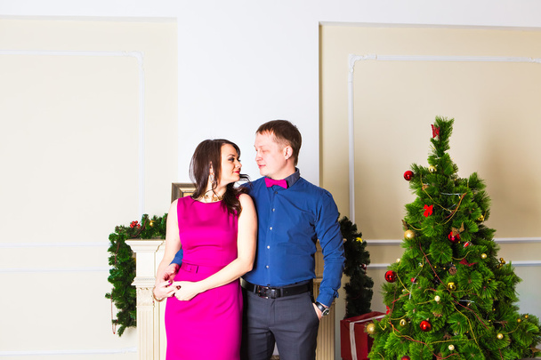 Young happy couple near  a Christmas tree - Foto, Imagen