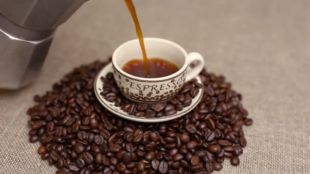コーヒー豆とコーヒーのカップを注ぐ - 映像、動画