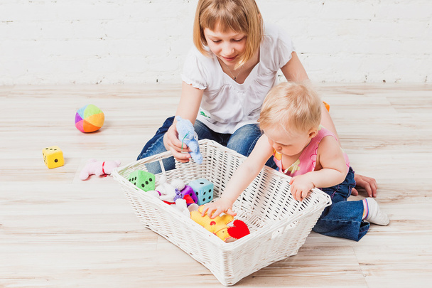 Baby girl and her older sister play with toys - Foto, Imagen