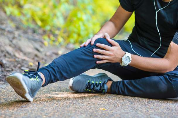 Atleta do sexo masculino que sofre de dor na perna durante o exercício ao ar livre
 - Foto, Imagem