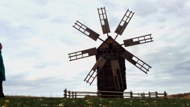 alte Windmühle auf dem Feld isolieren. Mädchen läuft auf der Straße in der Nähe von Windmühle. - Filmmaterial, Video