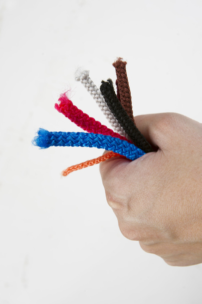 the hand with the colored end of the rope - Foto, Bild